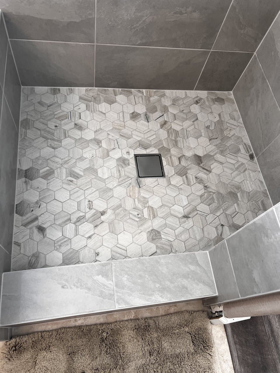 Hexagon mosaic tile shower floor with square drain detail