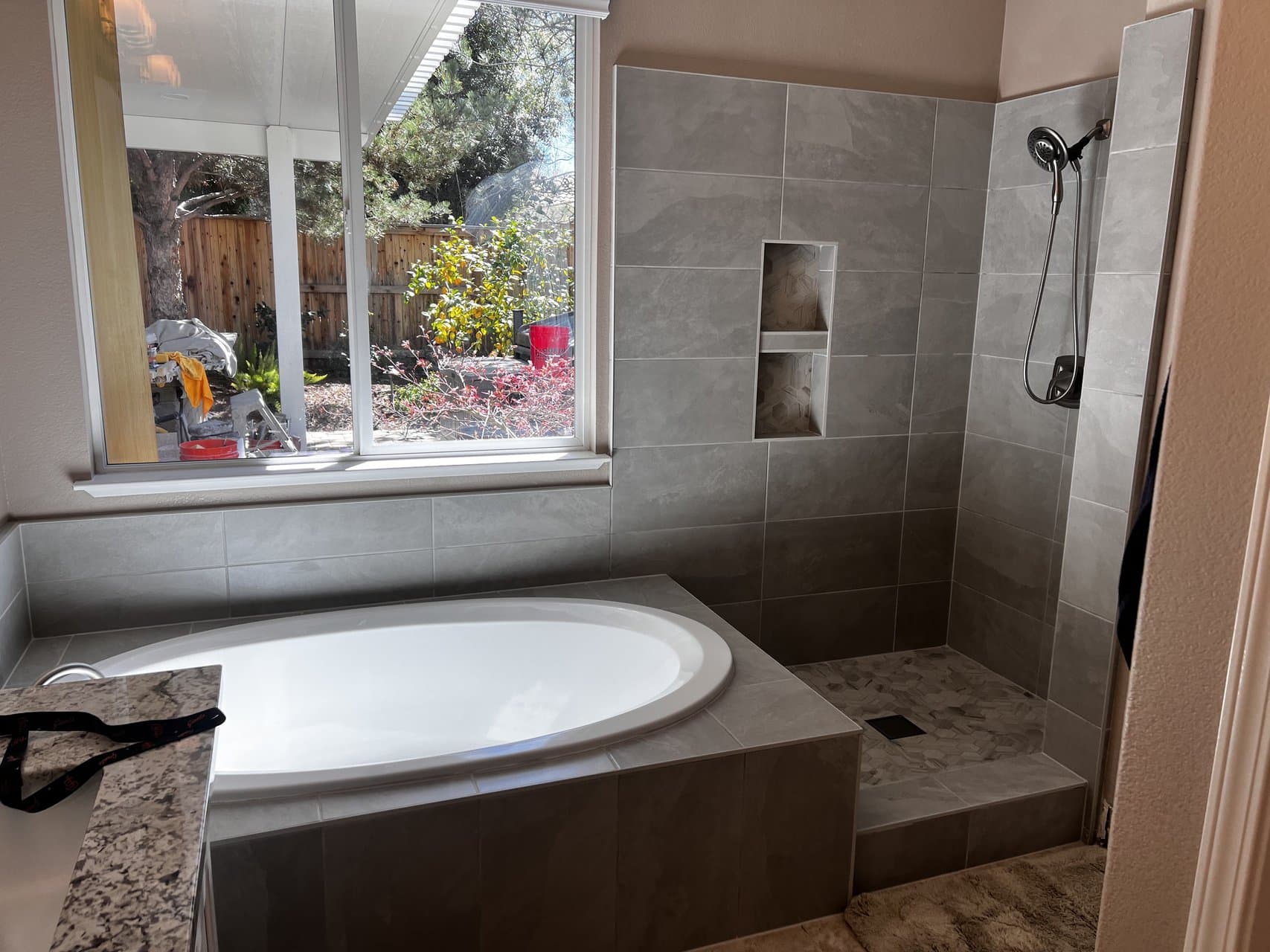 Master bathroom with soaking tub and walk-in tile shower with niche